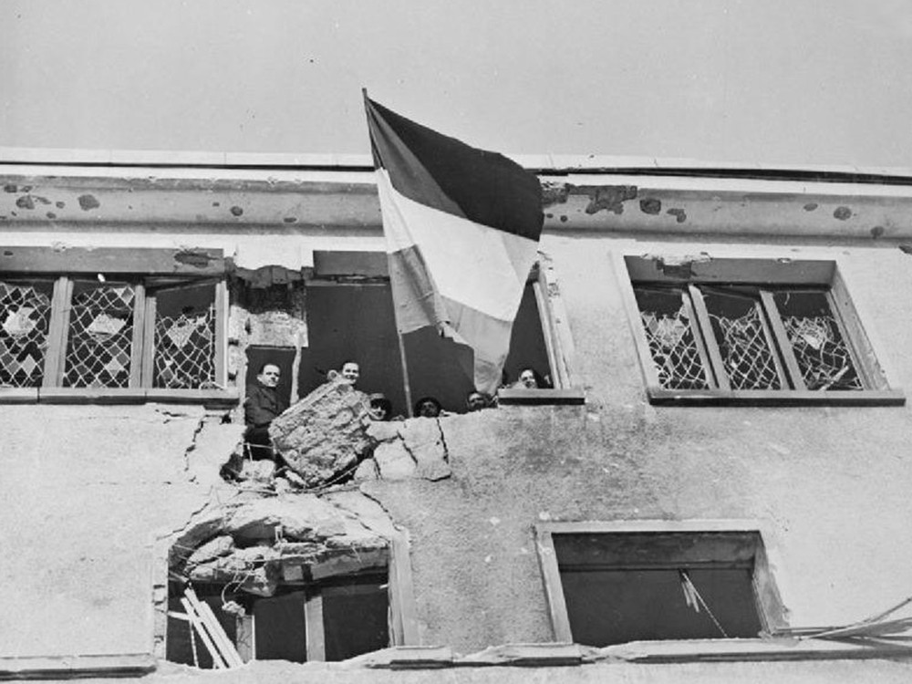 <p style="text-align: center;"><strong>The Allied Counter Attack 25 December 1944 - 28 January 1945: Civilians of Wiltz in Luxembourg at the window of the hospital, watch as the Luxembourg flag flies again after the town's liberation by the 4th Armoured Division on 25 December as Patton's 3rd Army began the attack which would relieve Bastogne.</strong><br style="text-align: center;" /><span style="text-align: center;">Source / Cr&eacute;dit :&nbsp;</span><a style="text-align: center;" href="https://commons.wikimedia.org/wiki/File:Liberation_of_Wiltz_in_Luxembourg.jpg?uselang=fr" target="_blank" rel="noopener">Imperial War Museum collection - Wikipedia CC</a></p>