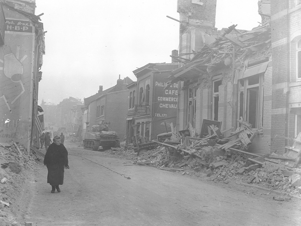 <p style="text-align: center;"><strong>Rue de Bastogne en ruines apr&egrave;s les bombardements de No&euml;l 1944 - Bastogne, 26 d&eacute;cembre 1944.</strong><br />Source / Cr&eacute;dit : <a href="https://commons.wikimedia.org/wiki/Category:Battle_of_the_Bulge_in_Bastogne?uselang=fr#/media/File:Photograph_of_Bomb_Damage_in_Bastogne,_Belgium_-_NARA_-_12010177.jpg" target="_blank" rel="noopener">U.S. National Archives and Records Administration - Wikipedia CC</a></p>