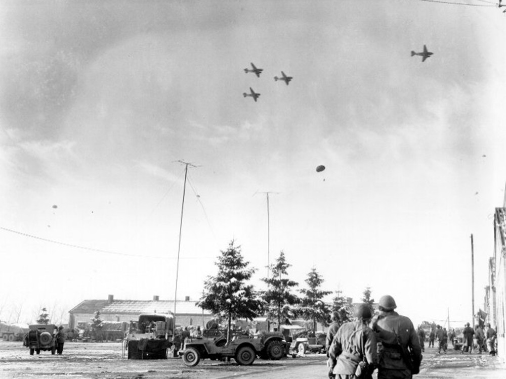 <p style="text-align: center;"><strong>Bastogne, Belgium. Troops of the 101st Airborne Division watch C-47&rsquo;s drop supplies to them. 26 December 1944.</strong><br style="text-align: center;" /><span style="text-align: center;">Source / Cr&eacute;dit :&nbsp;</span><a style="text-align: center;" href="https://commons.wikimedia.org/wiki/File:Watching_C-47%E2%80%99s_drop_supplies.jpg" target="_blank" rel="noopener">US Army - Wikipedia CC</a></p>