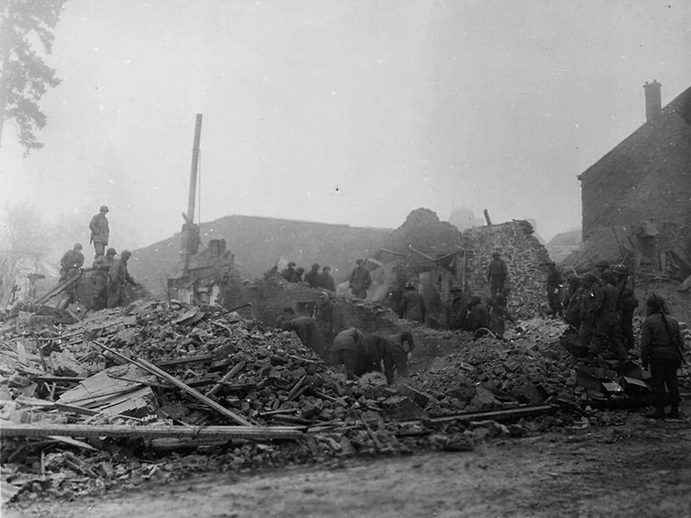 <p style="text-align: center;"><strong>Rue de Neufch&acirc;teau, Bastogne, following the destruction of the aid station. American soldiers sifting through the rubble - 25th December 1944</strong><br style="text-align: center;" /><span style="text-align: center;">Source / Cr&eacute;dit :&nbsp;</span><a style="text-align: center;" href="https://commons.wikimedia.org/wiki/File:Photograph_of_Members_of_the_101st_Airborne_Division_as_they_Move_out_of_Bastogne,_Belgium_-_NARA_-_12010172.jpg?uselang=fr" target="_blank" rel="noopener">U.S. National Archives and Records Administration - Wikipedia CC</a></p>